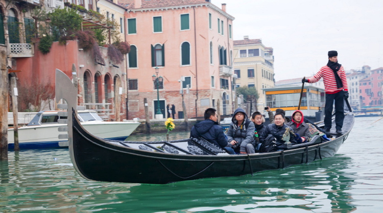Gondolier sailing in Venice Grand channel with chinese tourists