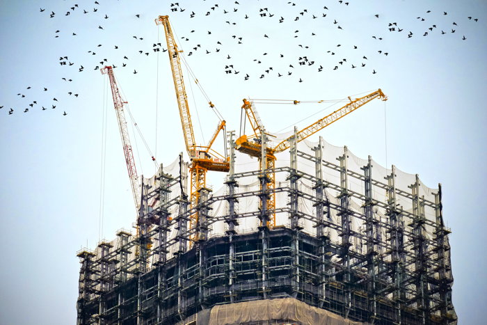 Construction cranes on top of building - Photo by 贝莉儿 NG on Unsplash
