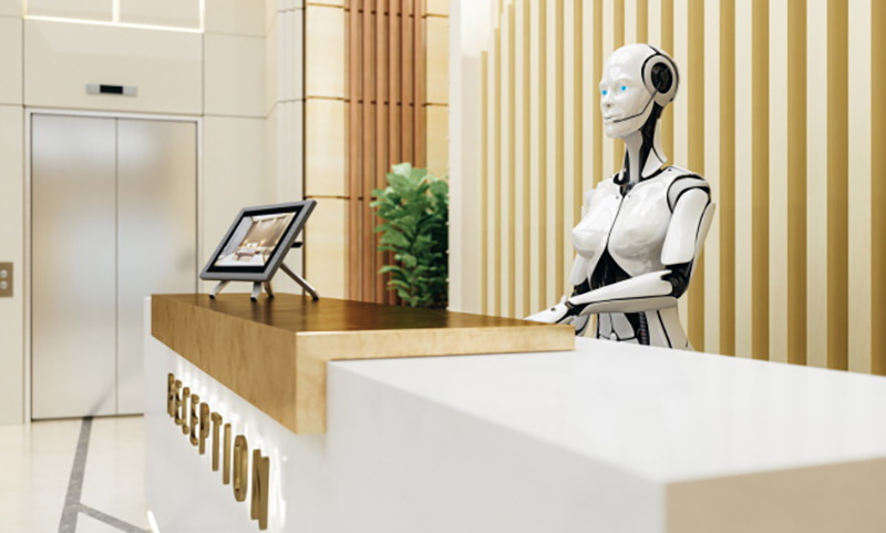 Un robot detrás del mostrador de recepción de un hotel - Source Puzzle Partner